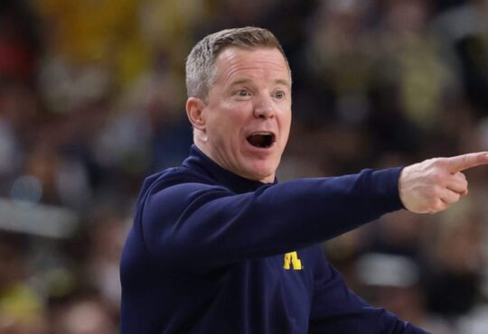 Michigan coach Dusty May shouts and points from the sideline during a game.