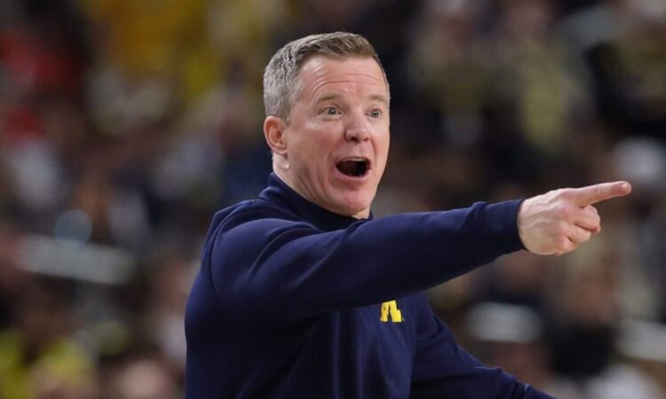 Michigan coach Dusty May shouts and points from the sideline during a game.