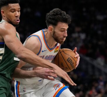 Giannis Antetokounmpo #34 of the Milwaukee Bucks defends Chet Holmgren #7 of the Oklahoma City Thunder at Fiserv Forum.