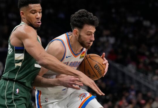 Giannis Antetokounmpo #34 of the Milwaukee Bucks defends Chet Holmgren #7 of the Oklahoma City Thunder at Fiserv Forum.