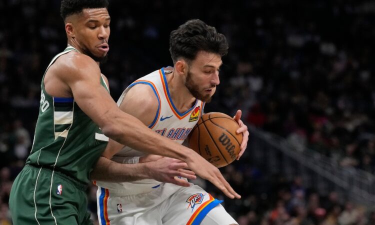 Giannis Antetokounmpo #34 of the Milwaukee Bucks defends Chet Holmgren #7 of the Oklahoma City Thunder at Fiserv Forum.