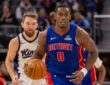 Detroit Pistons center Jalen Duren dribbles the ball up court ahead of Sacramento Kings forward Domantas Sabonis during a game at Little Caesars Arena