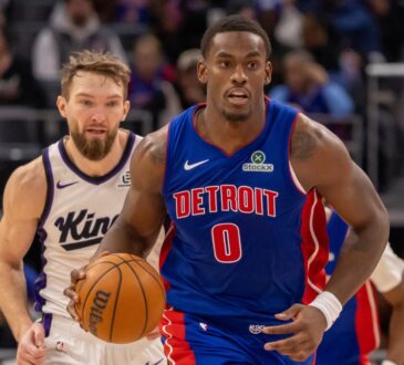 Detroit Pistons center Jalen Duren dribbles the ball up court ahead of Sacramento Kings forward Domantas Sabonis during a game at Little Caesars Arena