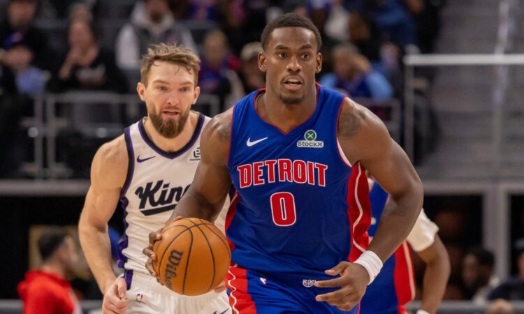 Detroit Pistons center Jalen Duren dribbles the ball up court ahead of Sacramento Kings forward Domantas Sabonis during a game at Little Caesars Arena