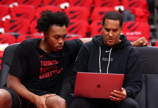 Toronto Raptors assistant coach and Mavericks head coaching candidate Jama Mahlalela reviews film on a laptop with forward Scottie Barnes on the bench