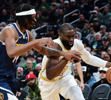 Boston Celtics guard Jaylen Brown controls the ball while Denver Nuggets forward Daron Holmes II defends during the first half at TD Garden