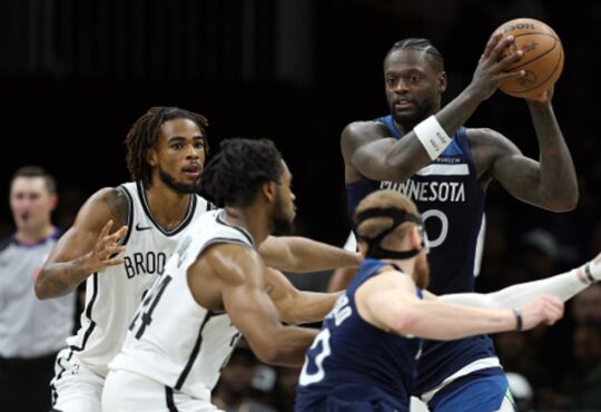 Julius Randle #30 of the Minnesota Timberwolves looks to pass against Cam Thomas #24 and Nic Claxton #33 of the Brooklyn Nets at Barclays Center.