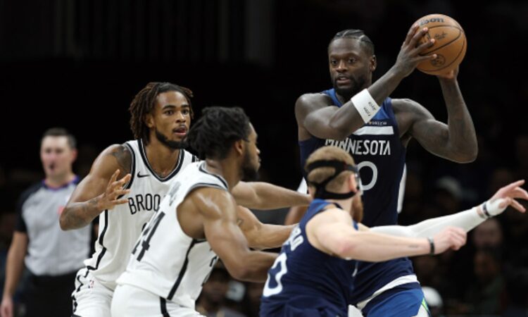 Julius Randle #30 of the Minnesota Timberwolves looks to pass against Cam Thomas #24 and Nic Claxton #33 of the Brooklyn Nets at Barclays Center.