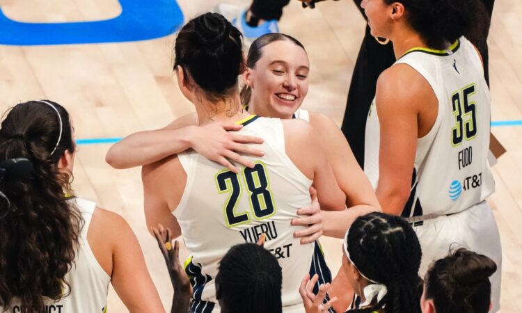 Dallas Wings guard Paige Bueckers embraces center Li Yueru as teammates celebrate a 2026 WNBA win over the Chicago Sky