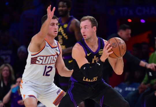 Los Angeles Lakers guard Luke Kennard controls the ball while defended by Phoenix Suns guard Collin Gillespie during a game at Crypto.com Arena