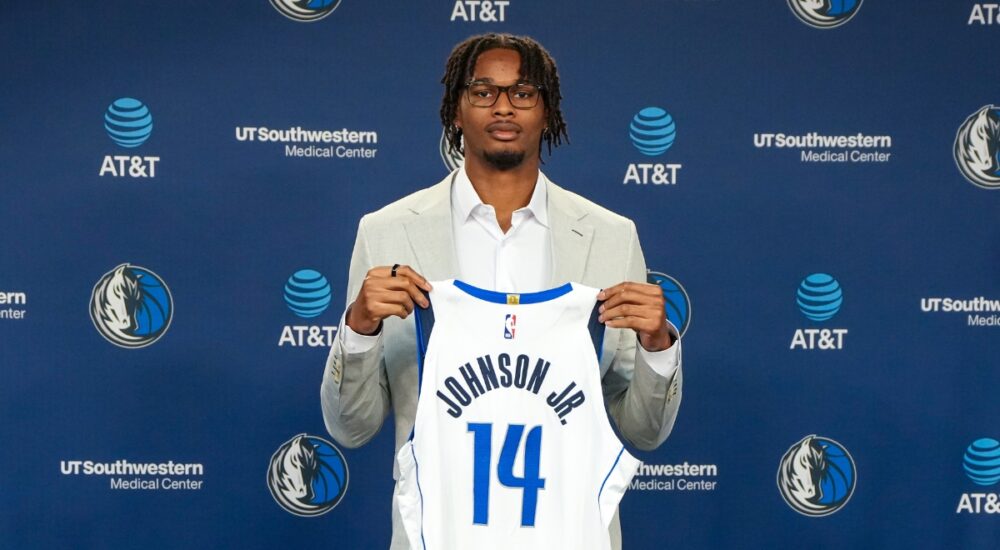 Morez Johnson Jr. holds his No. 14 Dallas Mavericks jersey at his introductory press conference
