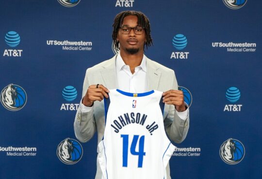 Morez Johnson Jr. holds his No. 14 Dallas Mavericks jersey at his introductory press conference