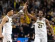 Morez Johnson Jr. in a white Michigan No. 21 jersey high-fives a teammate during the 2026 Final Four