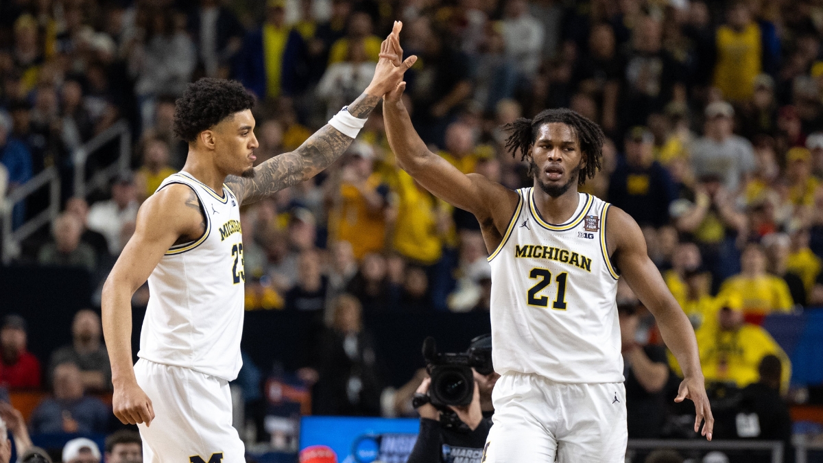 Morez Johnson Jr. in a white Michigan No. 21 jersey high-fives a teammate during the 2026 Final Four