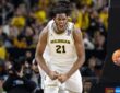 Morez Johnson Jr. flexes and celebrates in a white Michigan No. 21 jersey during the 2026 NCAA national championship game against UConn