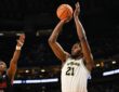Morez Johnson Jr. rises for a jump shot in a white Michigan No. 21 jersey over a Howard defender during the 2026 NCAA Tournament
