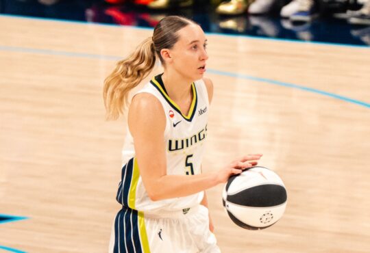 Paige Bueckers brings the ball up the court in a white Dallas Wings home uniform against the Phoenix Mercury on June 11, 2026