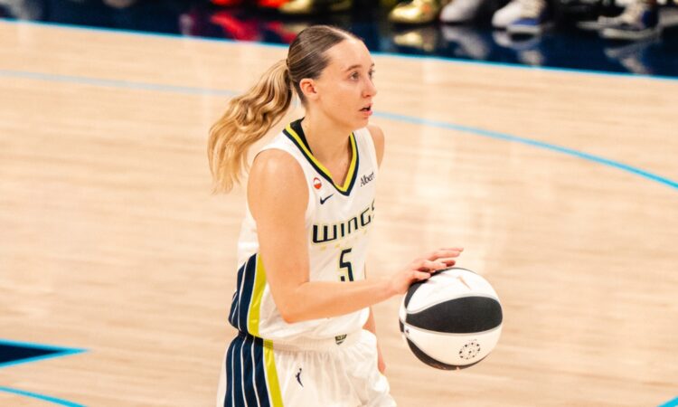 Paige Bueckers brings the ball up the court in a white Dallas Wings home uniform against the Phoenix Mercury on June 11, 2026