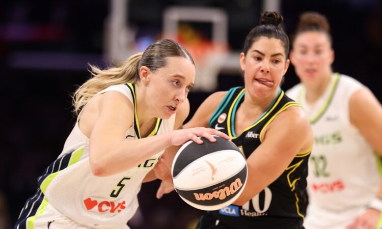 Paige Bueckers of the Dallas Wings protects the ball against Kelsey Plum of the Los Angeles Sparks at Crypto.com Arena.