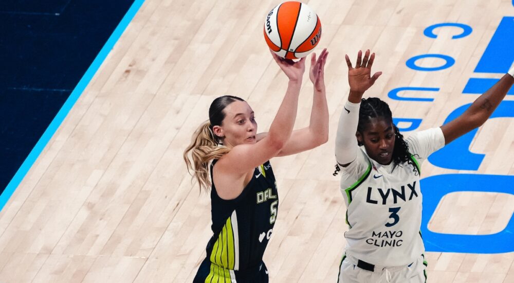 Dallas Wings guard Paige Bueckers rises for a jump shot over Minnesota Lynx guard Maya Caldwell during a WNBA game.