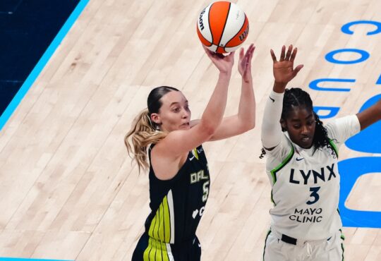 Dallas Wings guard Paige Bueckers rises for a jump shot over Minnesota Lynx guard Maya Caldwell during a WNBA game.