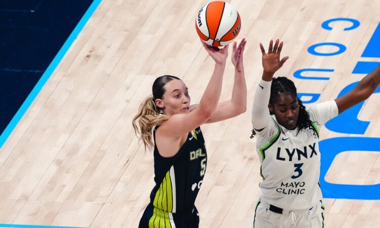 Dallas Wings guard Paige Bueckers rises for a jump shot over Minnesota Lynx guard Maya Caldwell during a WNBA game.