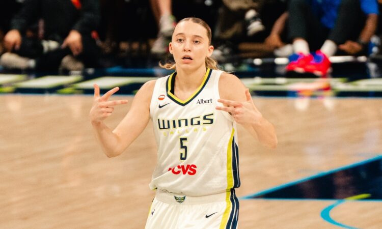 Paige Bueckers celebrates after a basket in a white Dallas Wings home uniform against the Phoenix Mercury on June 11, 2026
