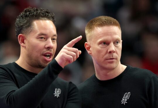 Sean Sweeney, a Mavericks head coach candidate, talks with Spurs coach Mitch Johnson
