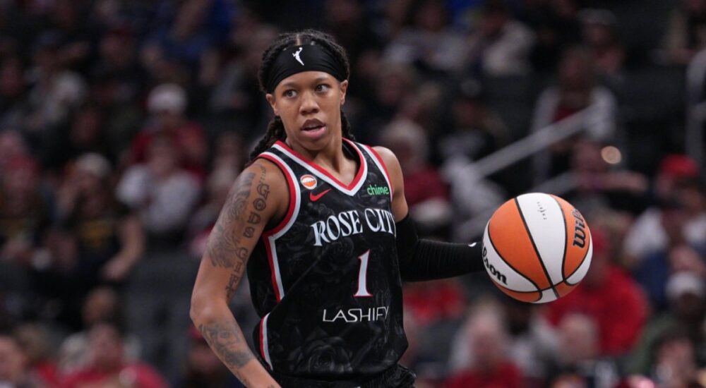 Sug Sutton dribbles up the court in a Portland Fire jersey during a game against the Indiana Fever