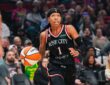 Sug Sutton dribbles up the court in a black Rose City Portland Fire jersey during a WNBA game