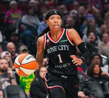 Sug Sutton dribbles up the court in a black Rose City Portland Fire jersey during a WNBA game