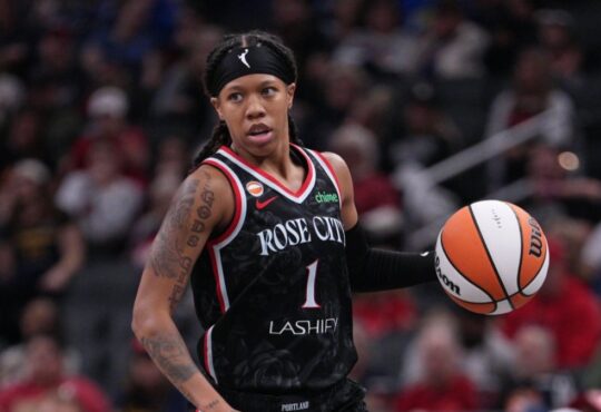 Sug Sutton dribbles up the court in a Portland Fire jersey during a game against the Indiana Fever