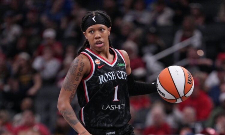 Sug Sutton dribbles up the court in a Portland Fire jersey during a game against the Indiana Fever
