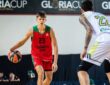 Vsevolod Ishchenko dribbles in a red and green Lokomotiv Kuban No. 23 jersey while a defender guards him during a game