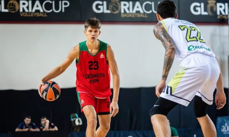 Vsevolod Ishchenko dribbles in a red and green Lokomotiv Kuban No. 23 jersey while a defender guards him during a game