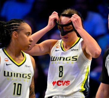 Alanna Smith of the Dallas Wings adjusts her protective mask after colliding with Gabriela Jaquez of the Chicago Sky during their WNBA game on June 20, 2026