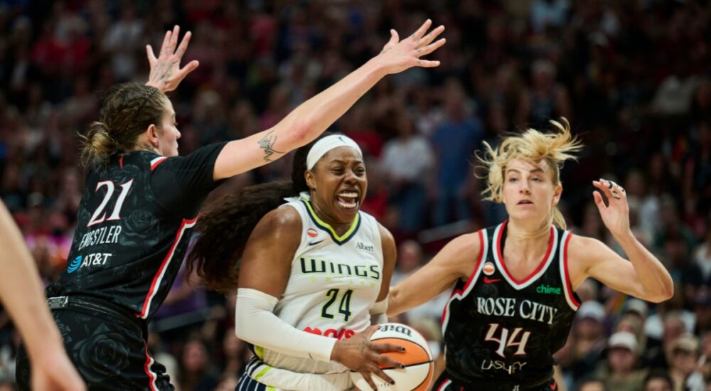 Dallas Wings guard Arike Ogunbowale drives to the basket between Portland Fire defenders Emily Engstler and Karlie Samuelson during the second half at Moda Center on July 22, 2026.