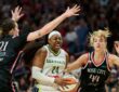 Dallas Wings guard Arike Ogunbowale drives to the basket between Portland Fire defenders Emily Engstler and Karlie Samuelson during the second half at Moda Center on July 22, 2026.