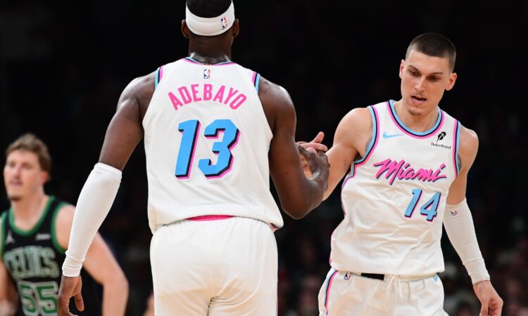 Miami Heat center Bam Adebayo #13 is congratulated by guard Tyler Herro #14 after making a basket against the Boston Celtics at TD Garden.