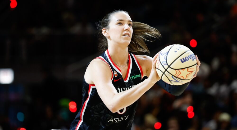 Portland Fire forward Bridget Carleton rises into her shooting motion, holding an All-Star Wilson ball with a rack visible at left, during the 2026 State Farm WNBA 3-Point Contest at Wintrust Arena in Chicago.
