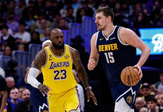 Denver Nuggets center Nikola Jokic controls the ball as Los Angeles Lakers forward LeBron James guards in the fourth quarter at Ball Arena.