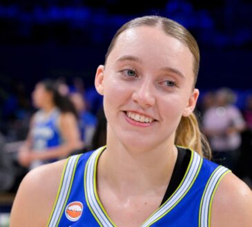 Dallas Wings guard Paige Bueckers smiles on the court at College Park Center after a game against the Las Vegas Aces.
