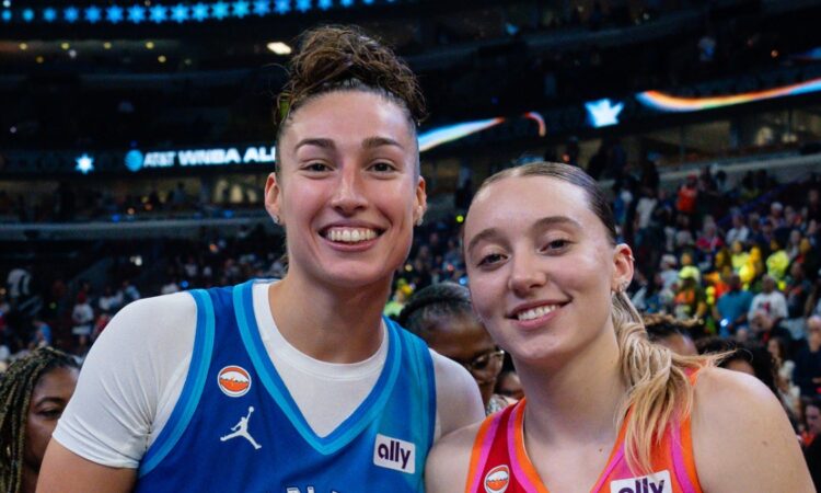 Jessica Shepard, in a blue Team Spoon jersey, and Paige Bueckers, in an orange Team Coop jersey, stand together and smile on the court after the 2026 WNBA All-Star Game.