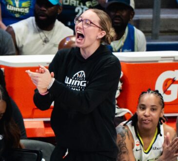 Dallas Wings guard Paige Bueckers claps and cheers from the sideline as guards Sug Sutton and Aziaha James applaud from the bench during a game against the New York Liberty at College Park Center.