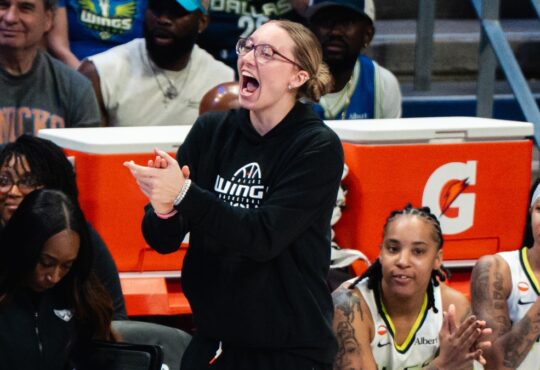 Dallas Wings guard Paige Bueckers claps and cheers from the sideline as guards Sug Sutton and Aziaha James applaud from the bench during a game against the New York Liberty at College Park Center.