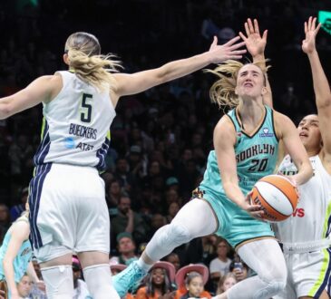 New York Liberty guard Sabrina Ionescu drives to the basket between Dallas Wings defenders Paige Bueckers and Azzi Fudd in the fourth quarter at Barclays Center