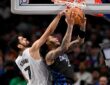Santi Aldama of the Memphis Grizzlies blocks a shot by P.J. Washington of the Dallas Mavericks
