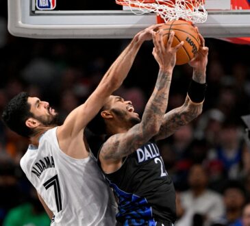 Santi Aldama of the Memphis Grizzlies blocks a shot by P.J. Washington of the Dallas Mavericks