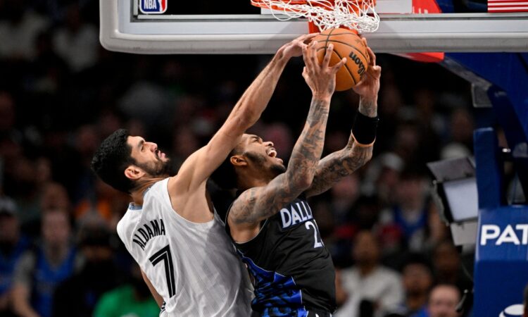 Santi Aldama of the Memphis Grizzlies blocks a shot by P.J. Washington of the Dallas Mavericks